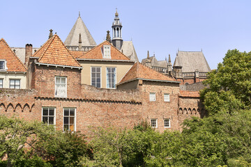Fototapeta na wymiar Zutphen's ancient city walls with homes and the Walburgis Church