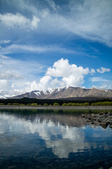 Pristine lake and snowy mountains against a blue sky.