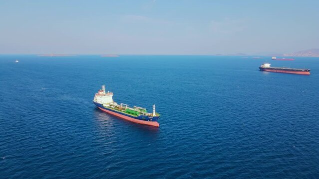 Oil chemical tanker in anchorage in sea waiting loading in industrial port, aerial shot