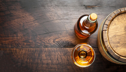 Scotch whiskey bottle, glass and old wooden barrel. With copy space. Top view flat lay