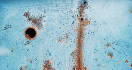 immagine primo piano di superficie in metallo verniciato, arrugginito e scrostato con foro circolare, vista da sopra