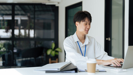 young businessman in white shirt sitting at desk and working on laptop. employee working at desk
