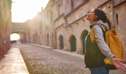 spring or fall trip to Rhodes island, Greece. Young Asian woman walks Street of Knights of...