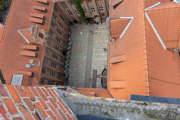 View of the old town courtyard made of red brick with ivy on the facade. summer time sightseeing and tourism concept.