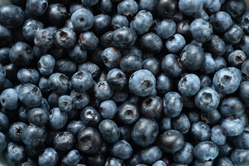 Blueberry background. Texture of fresh blueberries close-up. Sprinkle blueberries. Ripe blueberries with copy space. Scattered fresh blueberries. Selective focus