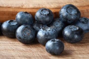 Blueberry. Fresh blueberries on a wooden surface close-up. Sprinkle blueberries. Scattered fresh blueberries. Healthy food concept. Selective focus
