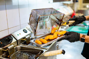 chef cooking cheese tempura in deep fry on kitchen