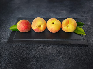 Harvest of peaches for food or juice. fresh organic fruit, vegan food. Large peaches on dark table background, selective focus.