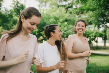 Happy women training in a park, jogging and having sport activity. Healthy lifestyle.