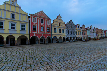 Wide-angle landscape view of colorful facade of historical buildings on the market square in Telc, the Czech Republic. Cloudy summer morning. UNESCO World Heritage Site