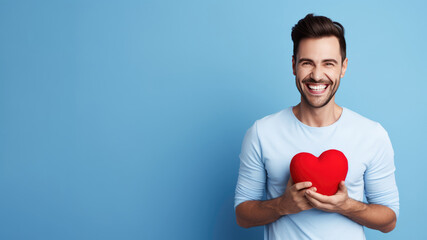 Smiling man holding small plastic heart isolated on blue background. AI Generated.