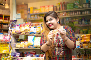 Indian woman showing bank card at grocery shop.