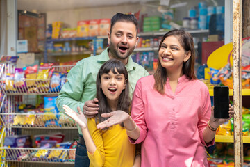 Happy Indian family at grocery shop.