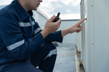 Asian maintenance engineer work on the roof of factory. contractor inspect compressor system and plans installation of air condition systems in construction. technology, walky talky, maintenance