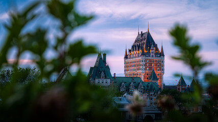 Fototapeta premium Nice view over the famous Chateau Frontenac hotel in the background, under the dusk light, blurred foreground. Old Quebec city, Canada