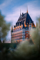 Fototapeta premium Nice view over the famous Chateau Frontenac hotel in the background, under the dusk light, blurred foreground. Old Quebec city, Canada