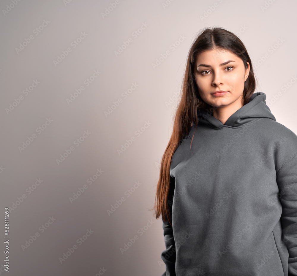 Poster brunette woman wearing a sweatshirt with a hood. beautiful girl blank one color jumper.