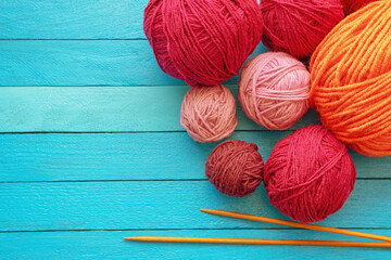 Hobbies and knitting concept. Balls of wool and  knitting needles on blue rustic table. Copy space