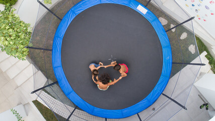 Children playing on trampoline aerial view together