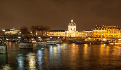 Fototapeta na wymiar River Seine with Pont des Arts and Institut de France panorama at night in Paris, France. High quality photo