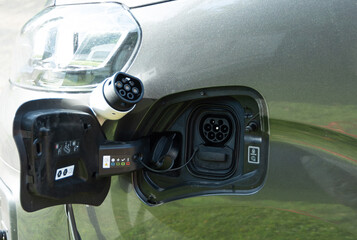 Close-up of CCS Type 2 electric charge plug and socket on grey van