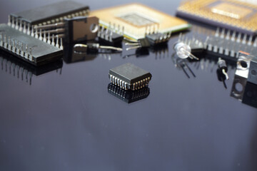 Semiconductor electronic components on black reflecting floor.. Focused on the chip.