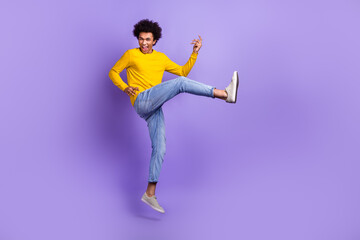Fototapeta na wymiar Full body photo of overjoyed cheerful man jumping arms playing imagine guitar empty space isolated on violet color background