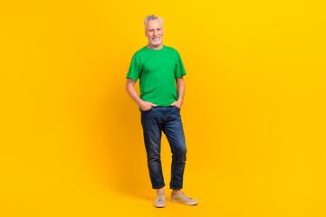 Fototapeta premium Full length photo of friendly satisfied glad aged person put hands pockets posing isolated on vivid yellow color background