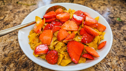 Freshly picked strawberries with corn flakes, drizzled with home-made elderflower cordial.