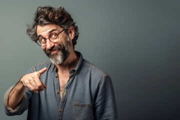 Obraz premium Funny Man pointing to blank space on gray background