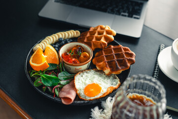 breakfast waffles with Fried Eggs fruit and ham.