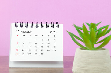 The November 2023 Monthly desk calendar for the organizer to plan 2023 year on wooden table background.