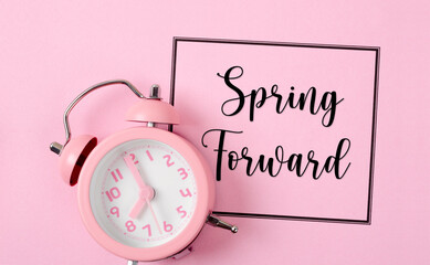 The Spring Forward with an alarm clock on pink color background.