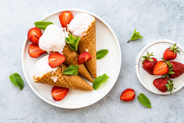 Homemade ice cream with fresh strawberries on stone table. Flat lay.