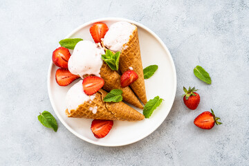 Homemade ice cream with fresh strawberries on stone table. Flat lay.