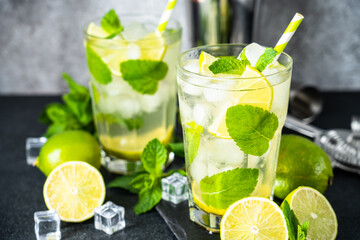 Mojito with rum, lime, mint and ice on black background. Tradition Summer drink.