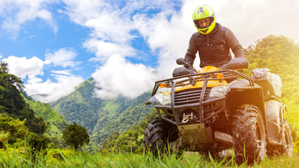 Man on quad bike. Tourist travels on ATV. Guy is into extreme racing. Quad bike driver in yellow...