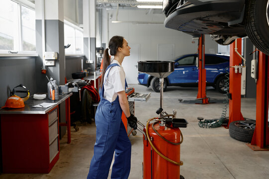 Woman mechanic pushing device for receiving used car engine oil