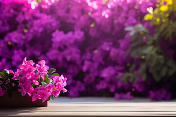 Empty wooden table top with blur pink tropical flower bush in background