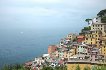Cinque Terre, Italy - view of sea and colorful houses in Riomaggiore, a seaside town on the Italian Riviera. Summer travel vacation background. Postcard from Europe. Italian architecture exterior.