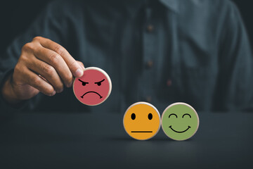 Unsatisfied customer holding frown icon on wooden circle. Conceptual representation of customer...