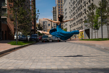 Beautiful Asian ballerina dancing outdoors. Urban landscape. Grand jete. 