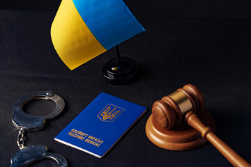 Ukrainian flag and handcuffs on black background, concept of crime and justice in the country