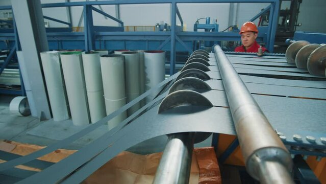Metal for roof at the modern metalwork factory. Product, rollers, workshop, stainless.