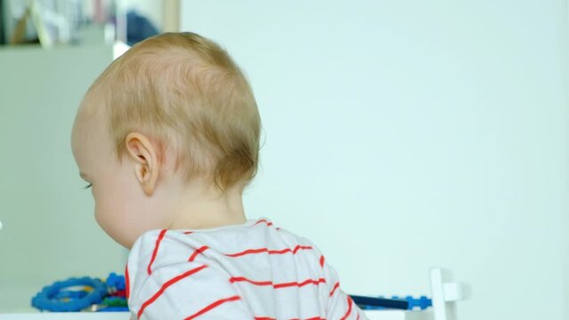 A sincere smile of a one-year-old child. Little boy looks at the camera and smiles.