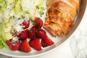 Healthy salad with chicken fillet, lettuce leaves and strawberry