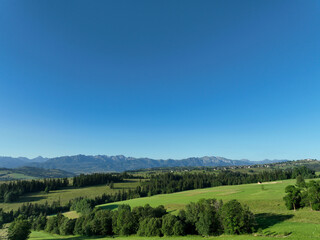 Fototapeta na wymiar zdjęcie przedstawiające krajobraz górski wysokie szczyty i doliny nad którymi jest niebieskie niebo z kłębiącymi się chmurami. Lasy w dolinach gór, krajobraz górski natura i cisza i spokój