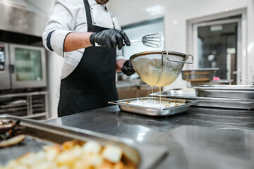 Chef cooking food at restaurant kitchen close up
