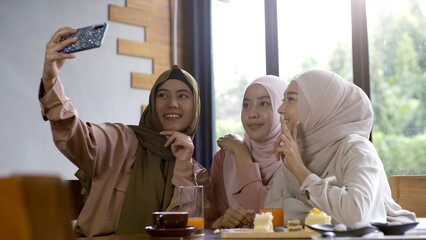 A group of successful upwardly mobile Asian Muslim friends relish a tranquil coffee shop gathering...