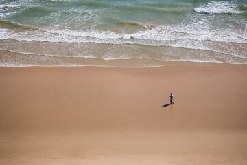 Lonely man watching cellphone on a beach